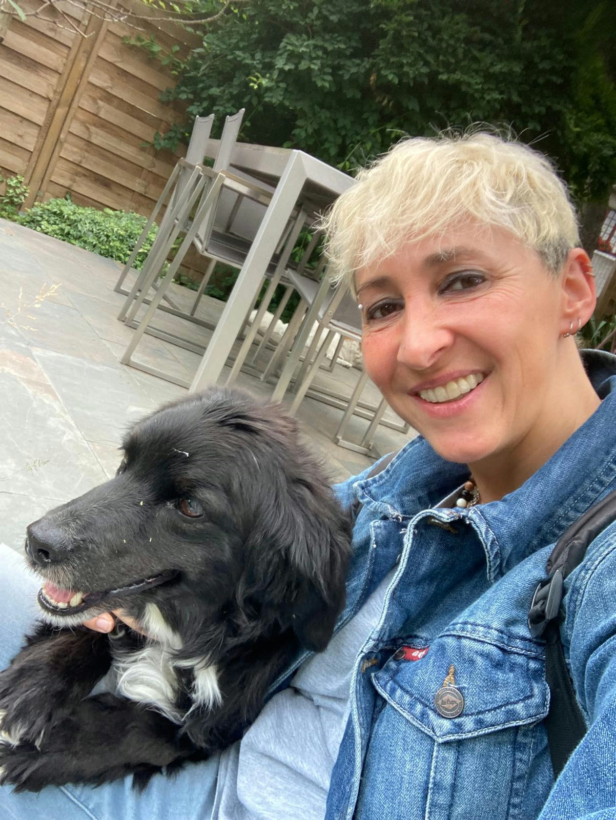 Élise, promeneuse, avec un chien noir sur une terrasse